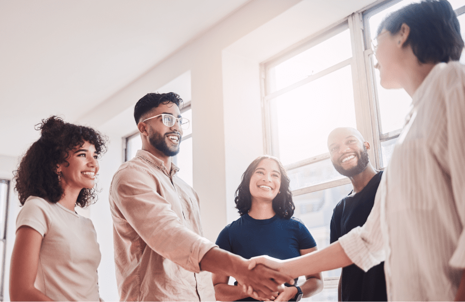 Group of people smiling and shaking hands.