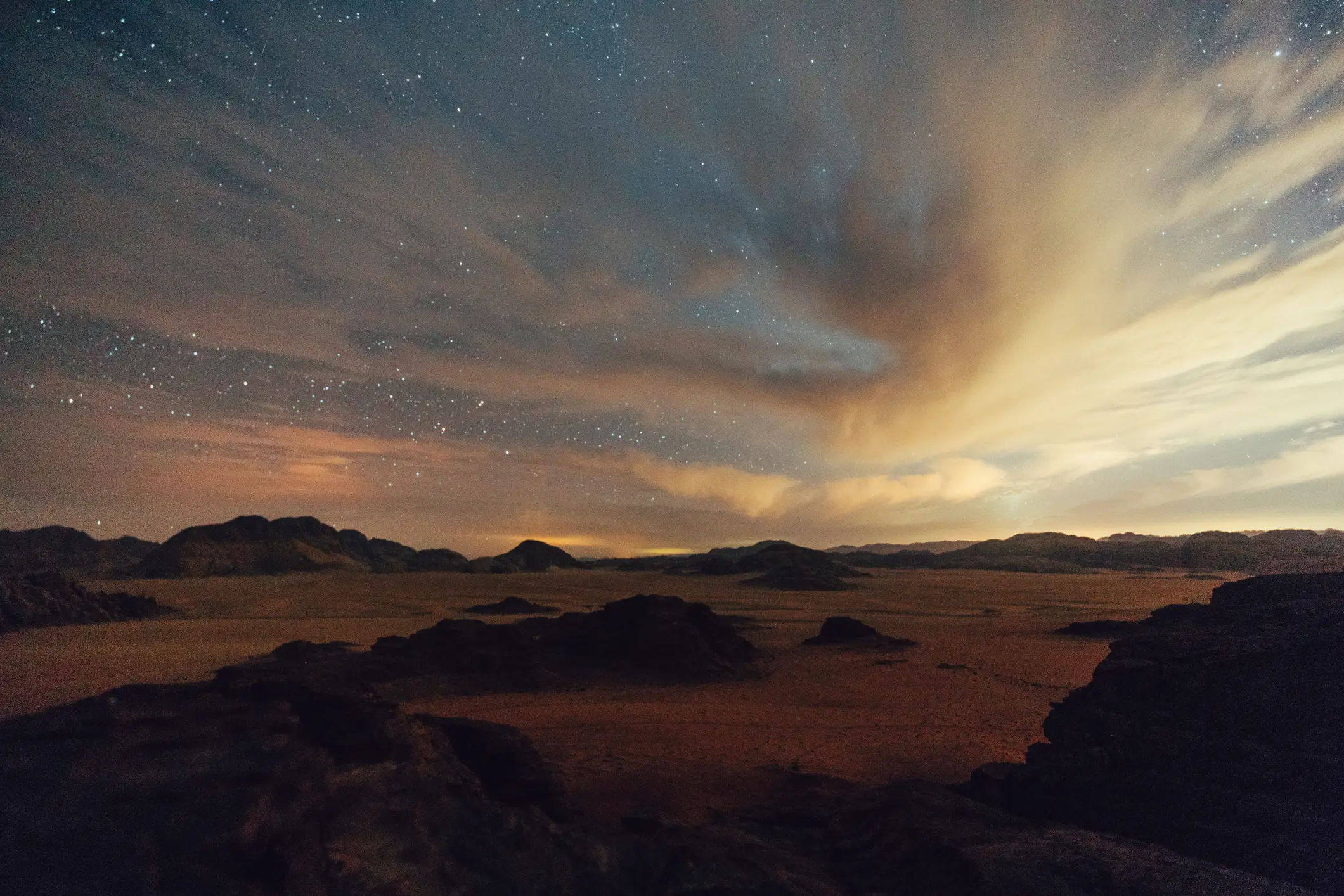 Starry night sky over desert rock formations